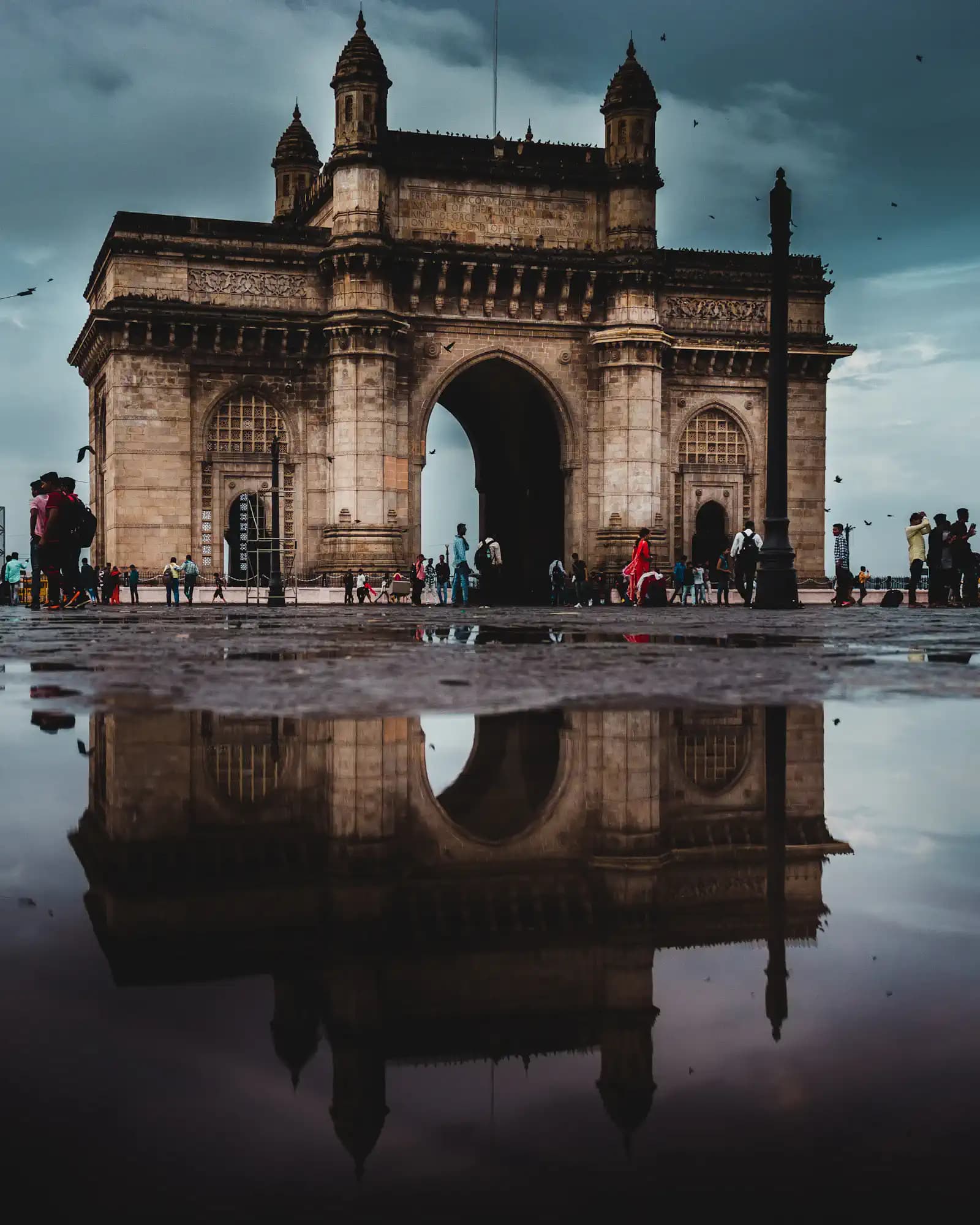 Gateway of India monument reflected in a puddle in Mumbai